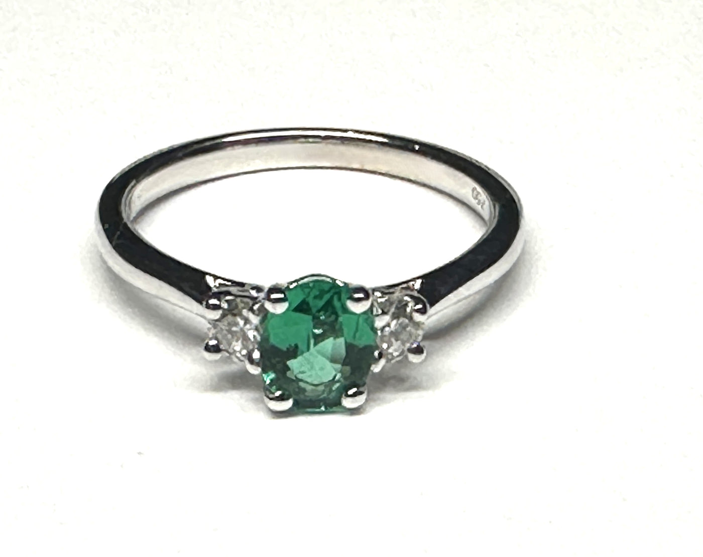 0.48ct Oval Emerald set in 18ct White gold with 2 x round diamond sides. finger size O