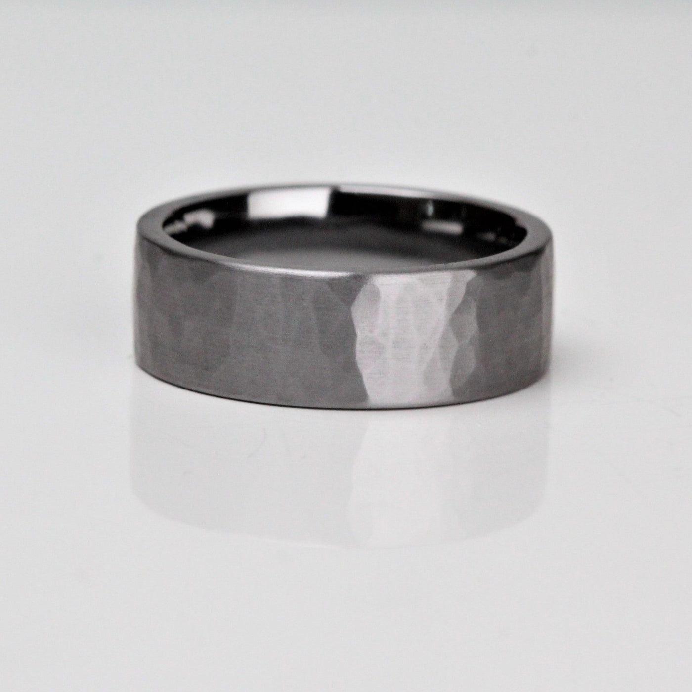 Dark metal wedding ring made of Tantalum. With a hammered and brushed finish. Flat outside with a comfort fit inside the ring