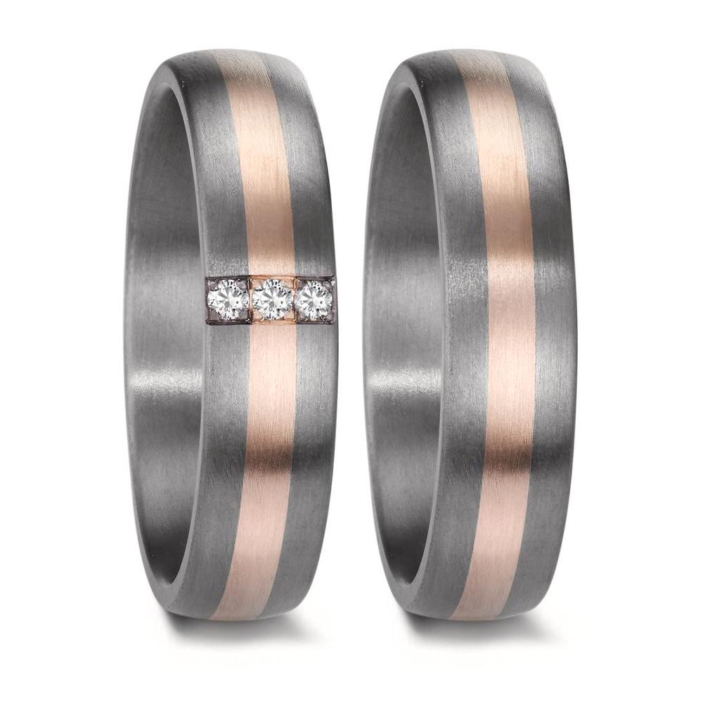 A matching wedding ring set crafted from tantalum and rose gold. The men's ring features a sleek, modern design with a central rose gold inlay, while the women's ring is adorned with three sparkling diamonds, complementing the warm rose gold accent set into the rich, dark tantalum