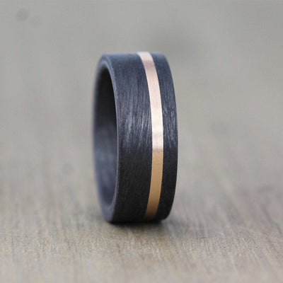 black carbon fibre wedding ring band. 8mm wide with a stripe of rose gold. black mans wedding ring uk