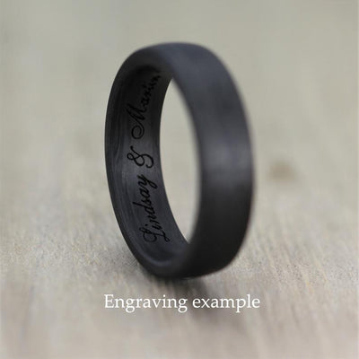 black wedding ring made of carbon fibre with english script engraving inside